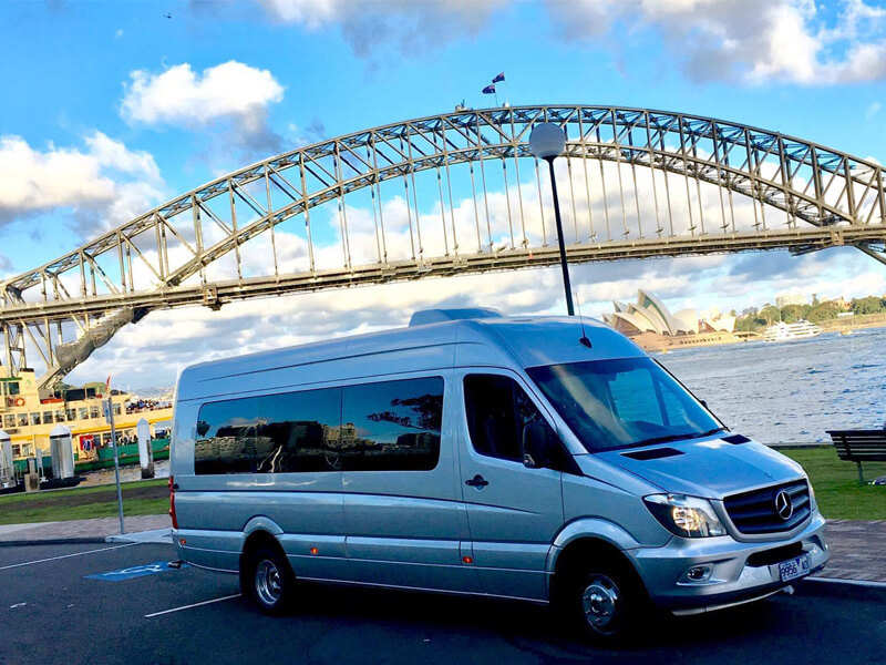 Mini bus charter driving near Sydney Harbour Bridge